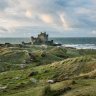 Bamburgh Castle rising above grassy dunes on the Northumberland coast
